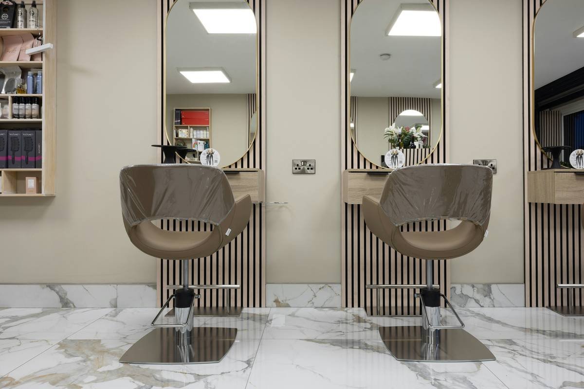 Ergonomic beauty design: professional makeup artist seated in an adjustable, supportive chair with proper lumbar support and neutral posture