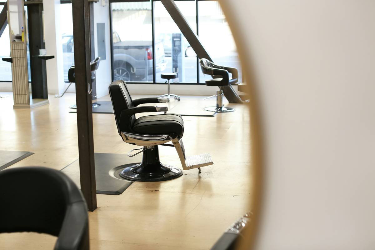Professional makeup chair furniture with adjustable height and padded backrest in a well-lit vanity area